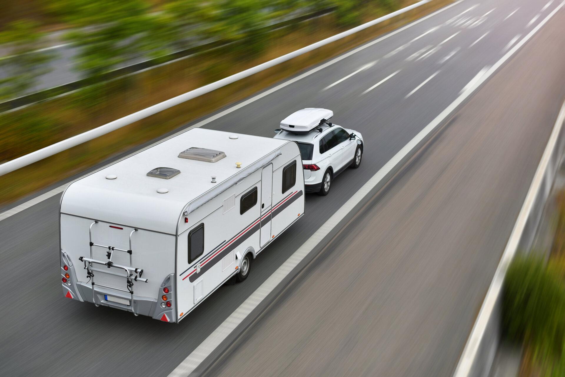 Reise mit Auto und Wohnwagen auf der Autobahn