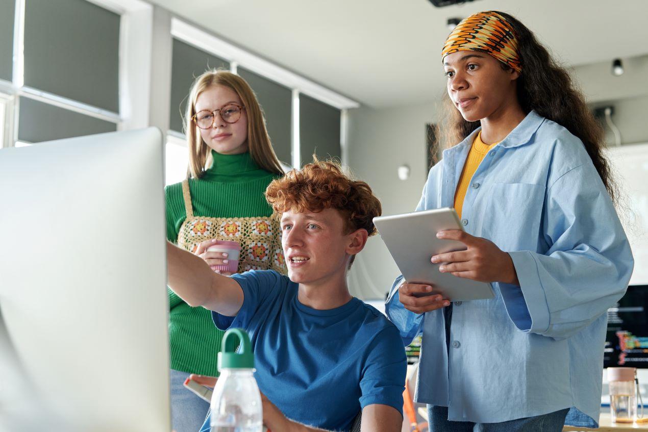 Drei Schüler eines Gymnasiums privat Berlin arbeiten gemeinsam an einem Projekt am Computer