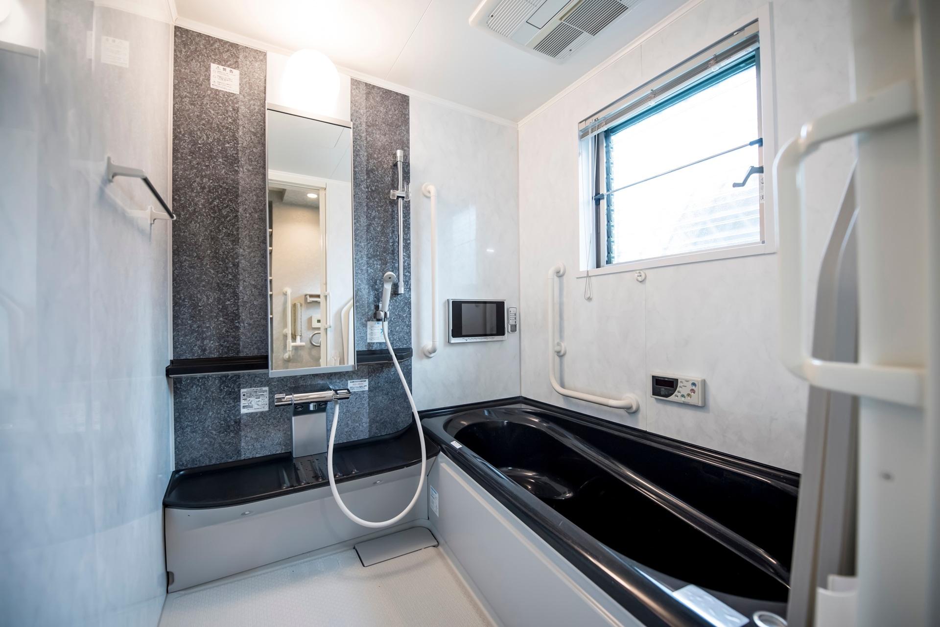 Bad mit Haltegriffen und TV | fugenlose Wandverkleidung Dusche