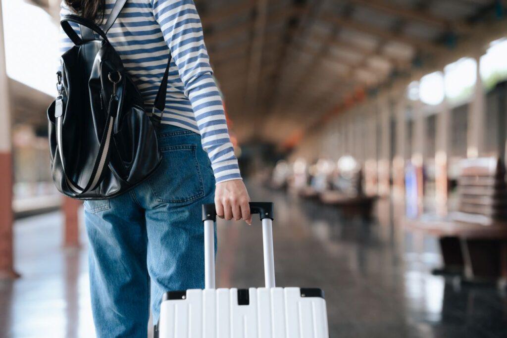Reisende mit Koffer am Bahnsteig – Entscheidung zwischen Bahn und Flughafen Shuttle Frankfurt fuer klimaschonende Anreise