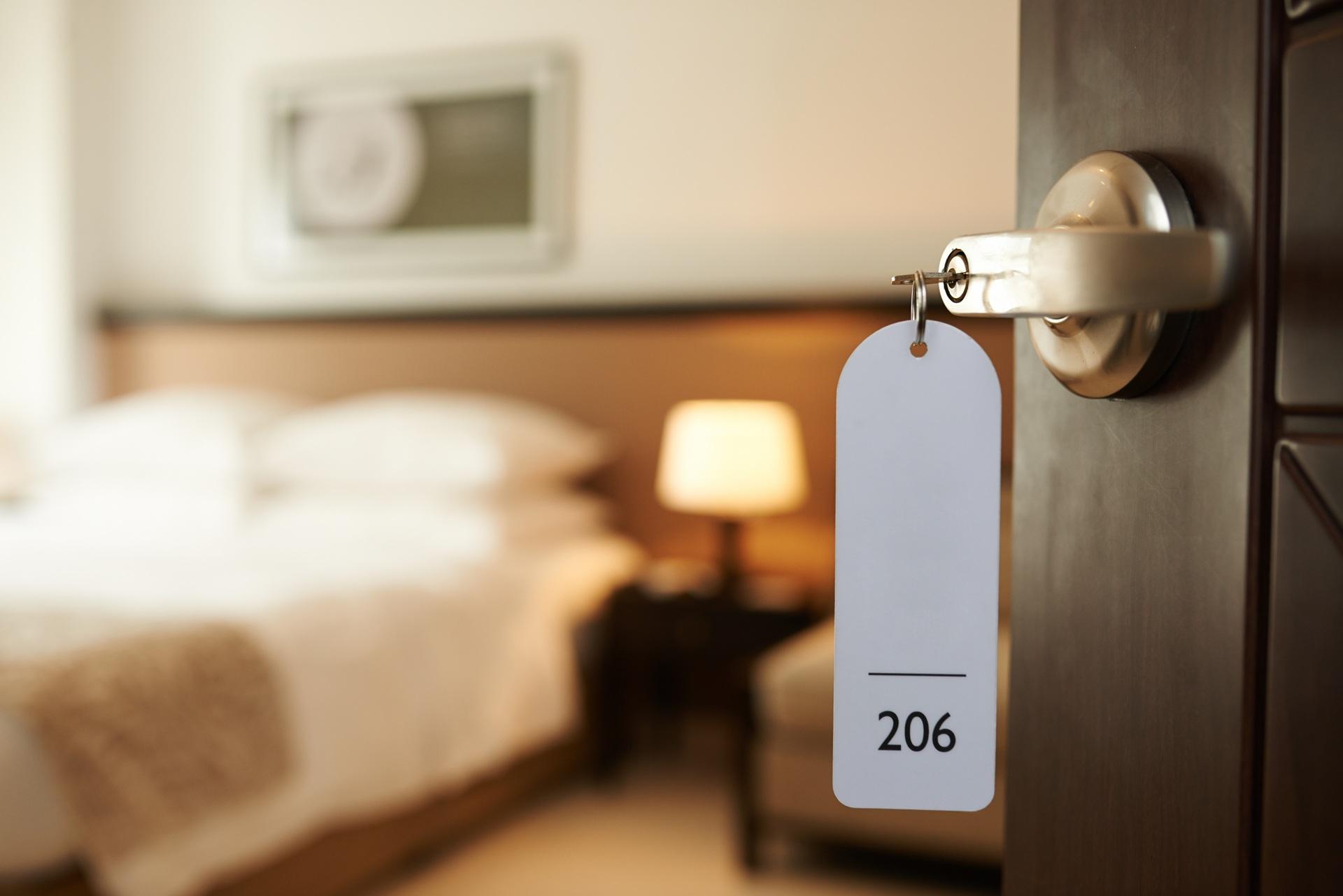 Geöffnete Hoteltür mit Schlüsselanhänger und Blick ins Zimmer | Eckkleiderschrank