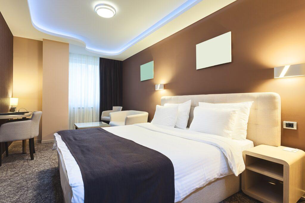Modern eingerichtetes Hotelzimmer mit Doppelbett | Eckkleiderschrank