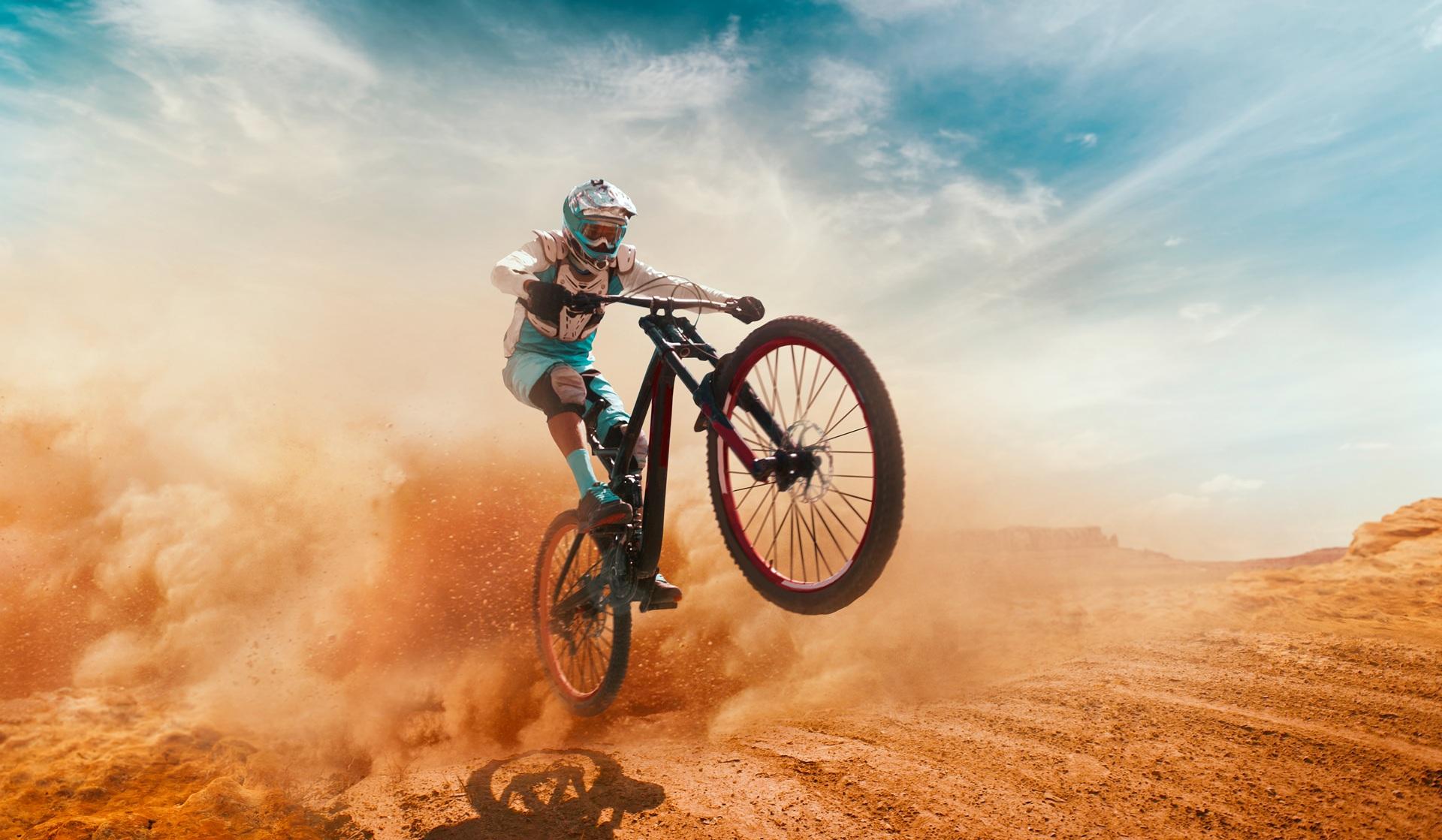Sportler mit Mountainbike bei Sprung im Staub | Inlinehockey